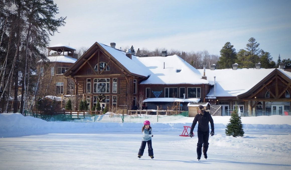 Un papa et sa fille sur une patinoire au Québec en hiver