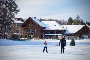 Un papa et sa fille sur une patinoire au Québec en hiver